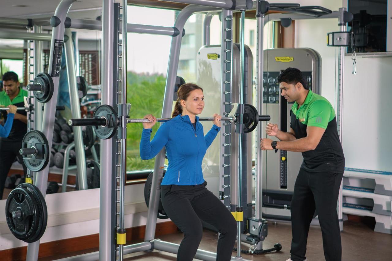 Jumeirah Messilah Beach Hotel&Spa Kuwait Kuwait City Bagian luar foto A personal trainer assisting a woman with a squat