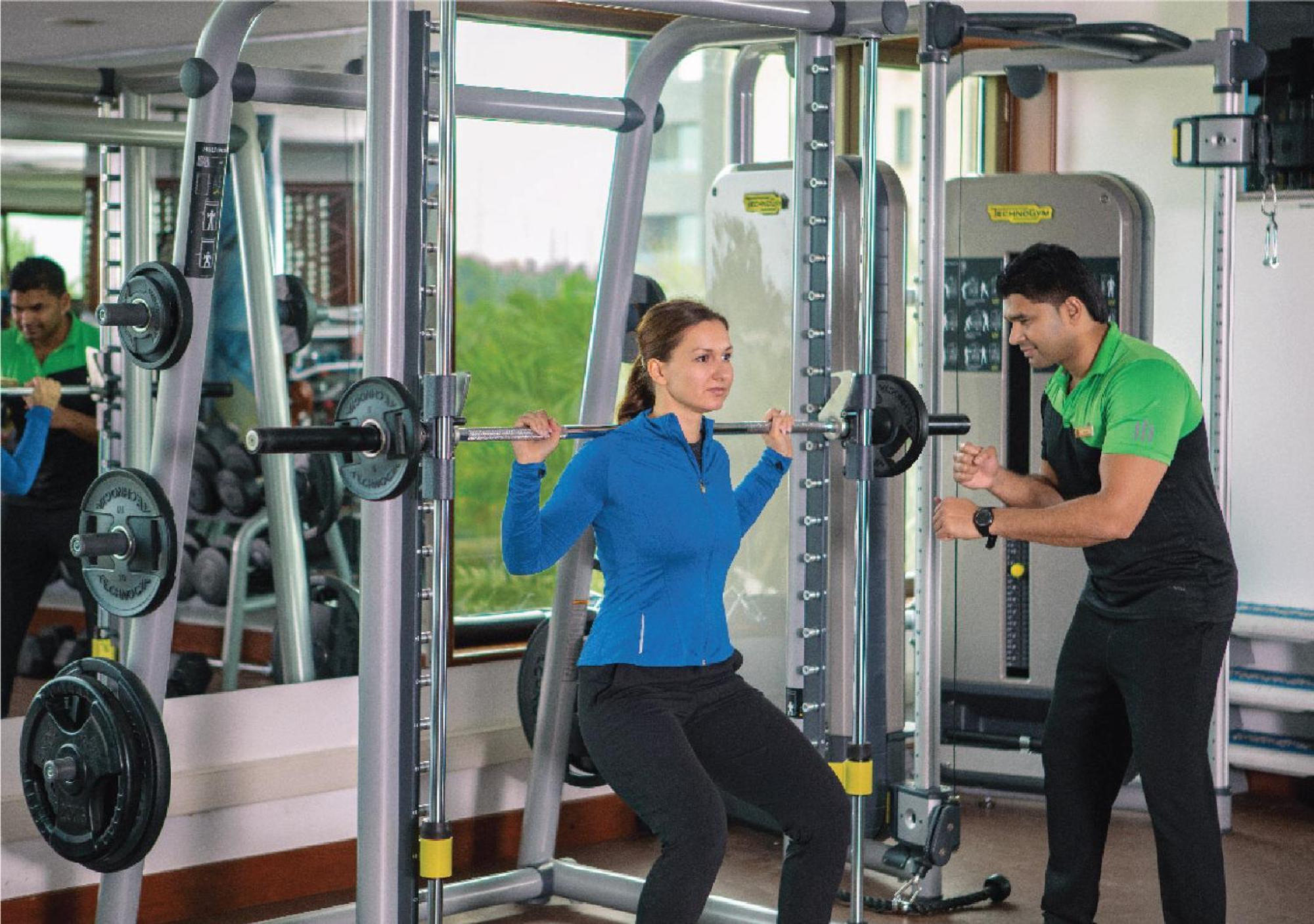 Jumeirah Messilah Beach Hotel&Spa Kuwait Kuwait City Bagian luar foto A personal trainer assisting a woman with a weight training exercise